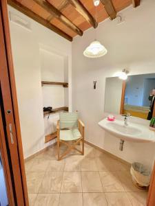 uma casa de banho com um lavatório e uma cadeira em B&B Alloro em Capannori