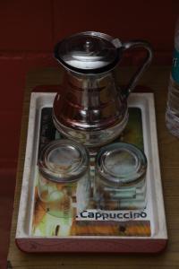 a tea pot and glasses on a tray on a table at Sai Home Stay in Madikeri