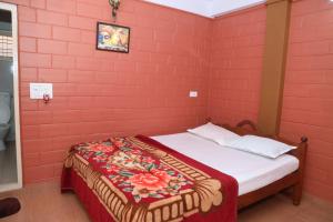 a bedroom with a red brick wall with a bed at Sai Home Stay in Madikeri