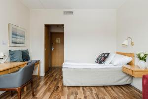 1 dormitorio con cama, escritorio y mesa en Hotell Kramm, en Kramfors