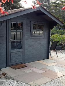 a black shed with a chair in it at Delightful cosy cabin in Margate