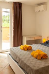 a bedroom with a bed with yellow towels on it at MARIS Apartments & Bedrooms in Alghero