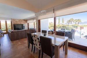 Beautiful Villa Bohemia Ibiza في سان خوسيه دي سا أتاليا: غرفة طعام وغرفة معيشة مع طاولة وكراسي