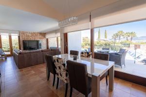 a dining room and living room with a table and chairs at Beautiful Villa Bohemia Ibiza in Sant Josep de sa Talaia