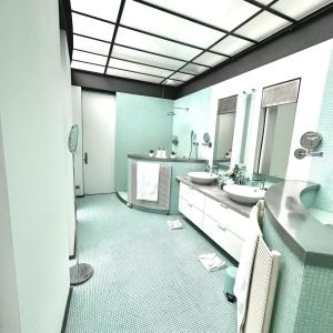 uma casa de banho com dois lavatórios e dois espelhos em Les Lofts d'Artistes em Bruxelas