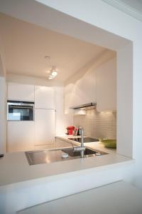 a kitchen with white cabinets and a sink at Blue dunes, Knokke in Knokke-Heist