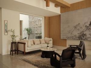 a living room with a couch and a table and a chair at Guilin Bonjour Boutique Hotel- Free pick up service over 3 nights in Guilin