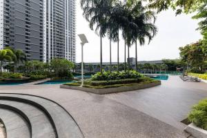 een park met palmbomen en een gebouw bij Family-friendly APT 3BR Above Mall-PoolGym MITEC in Kuala Lumpur