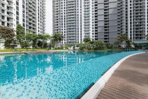 een groot zwembad met hoge gebouwen op de achtergrond bij Family-friendly APT 3BR Above Mall-PoolGym MITEC in Kuala Lumpur