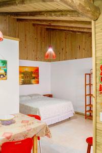 a bedroom with two beds and a table and chairs at Pousada Villa Del Mar in Farol de Santa Marta