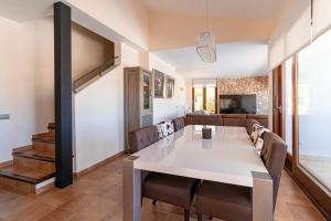 comedor y sala de estar con mesa blanca y sillas en Beautiful Villa Bohemia Ibiza, en Sant Josep de sa Talaia
