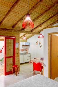 a room with a table and two red chairs at CABANAS Villa Del Mar in Farol de Santa Marta