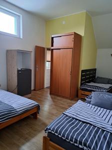 Cette chambre comprend 2 lits et une armoire. dans l'établissement Penzion a Restaurace Na Záložně, à Kobylí