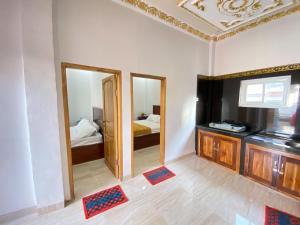 a room with two mirrors and a bedroom with a bed at Rumah Windy Guest House Bira in Bira