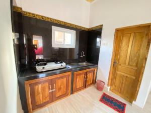 cocina con encimera, fregadero y puerta en Rumah Windy Guest House Bira en Bira