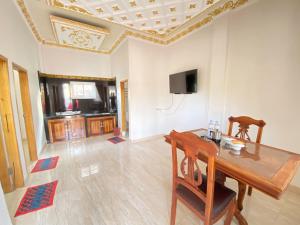 a living room with a table and a tv at Rumah Windy Guest House Bira in Bira