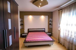 a bedroom with a large bed with a pink blanket at Casa Bibi in 2 Mai