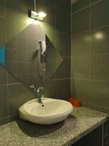 a bathroom with a sink and a light on a wall at Masawi Home in Can Tho