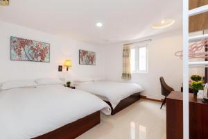 um quarto com 2 camas, uma secretária e uma janela em Cabana Hotel - 47A Nguyen Trai, Q1 - by Bay Luxury em Ho Chi Minh