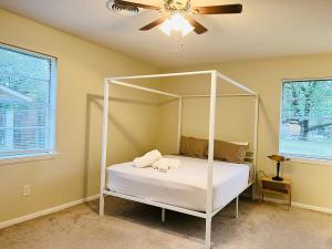 a bedroom with a white canopy bed with a fan at The Lil' Yellow Door8 in Durant