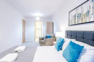 a bedroom with a large white bed with blue pillows at Spacious 2-Bedroom Apartment in the Heart of Manchester - Ideal for Families or Groups in Manchester