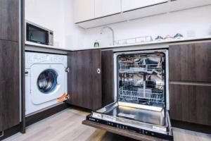 a kitchen with a dishwasher and a washer at Spacious 2-Bedroom Apartment in the Heart of Manchester - Ideal for Families or Groups in Manchester