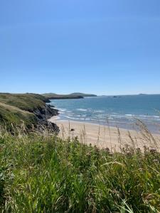 a sandy beach with the ocean in the background at Craig-Y-Mor Bed & Breakfast with sea views Whitesands St Davids in St. Davids