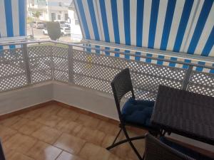 a balcony with a table and chairs on a balcony at Piso en la Costilla-Rota in Rota