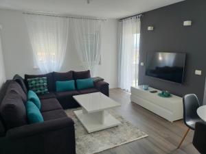 a living room with a couch and a tv at Apartment Maria in Tomislavgrad