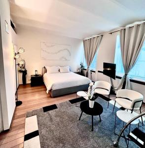 a bedroom with a bed and chairs and a television at Les Lofts d'Artistes in Brussels