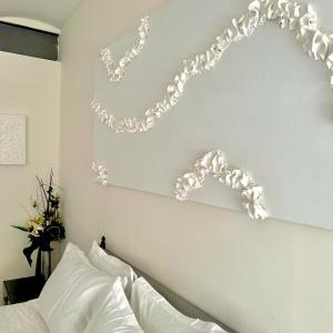 a bedroom with a white wall with a chain above a bed at Les Lofts d'Artistes in Brussels