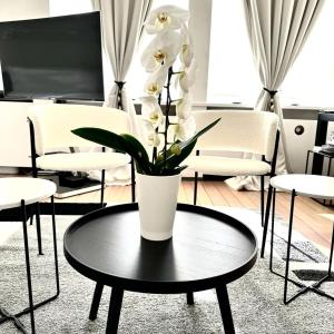 un vase avec des fleurs blanches sur une table dans une pièce dans l'établissement Les Lofts d'Artistes, à Bruxelles
