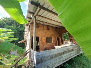 a wooden house with a large green leaf at Le Chalet, Eco Farm Stay in Vieux Grand Port