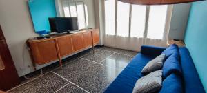 a living room with a blue couch and a tv at Le Caravelle in Rapallo