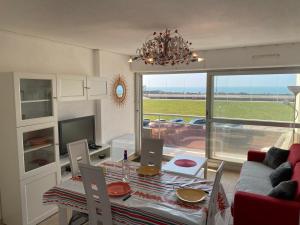 un soggiorno con tavolo, divano e TV di Superbe Appartement Superbe Vue Océan a Biscarrosse