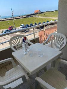 tavolo e sedie bianchi con vista sull'autostrada di Superbe Appartement Superbe Vue Océan a Biscarrosse