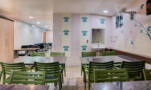un ristorante con tavoli e sedie verdi di Treebo Trend Golden Inn 700 Mtrs From Promenade Beach a Pondicherry