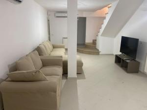 a living room with a couch and a television at Luxury beach house in Porto Santo Stefano