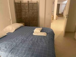 a blue bed with two towels on top of it at Luxury beach house in Porto Santo Stefano