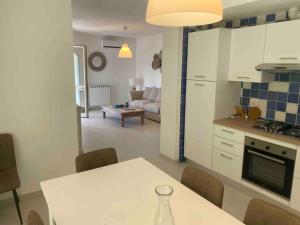 uma cozinha e sala de estar com uma mesa e um sofá em Luxury beach house em Porto Santo Stefano