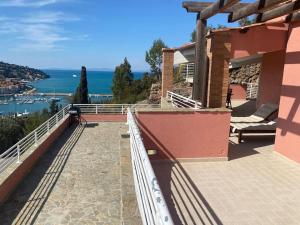 uma varanda de uma casa com vista para a água em Luxury beach house em Porto Santo Stefano