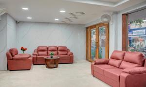 a waiting room with red leather chairs and a table at Treebo Trend Golden Inn 700 Mtrs From Promenade Beach in Pondicherry