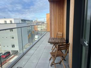 Un balcón con una mesa de madera y una silla en un edificio en Iceland SJF Apartments - 503, en Reikiavik