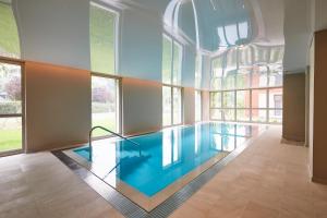 a swimming pool in a room with windows at Le Domaine des Diamants Blancs in Croix