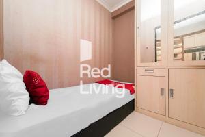 丹格朗的住宿－RedLiving Apartemen Paragon Village Karawaci - Ujang Rooms，一间卧室配有一张带红色枕头的床
