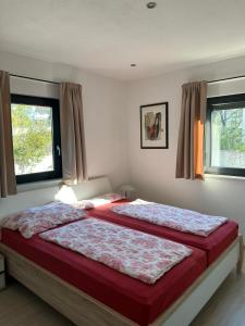 two beds in a bedroom with two windows at Villa Antunovic in Malinska