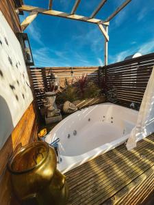 a bath tub sitting on top of a deck at 2 Bedroom Roof Terrace SPA with Sauna plus Jakuzzi and Outdoor Cinema in London