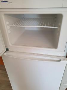 einem leeren Kühlschrank mit offener Tür in der Küche in der Unterkunft Haus Oveney in Bochum