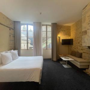 a hotel room with a large bed and a couch at Le Roscanvec in Vannes