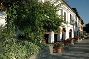 un edificio con piante in vaso sul lato di una strada di Hotel Arnaldo Aquila D’oro a Rubiera